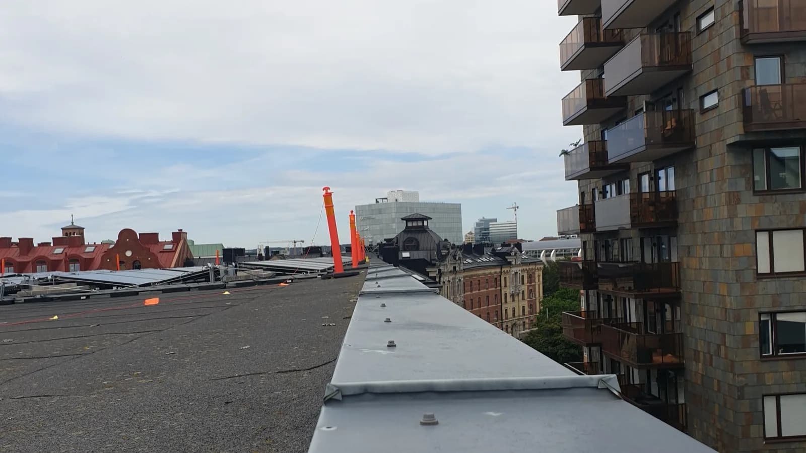 Det platta papptaket på fastigheten vid Heden i centrala Göteborg, fotograferat uppifrån längs den nya krönplåten med stadens tak i bakgrunden
